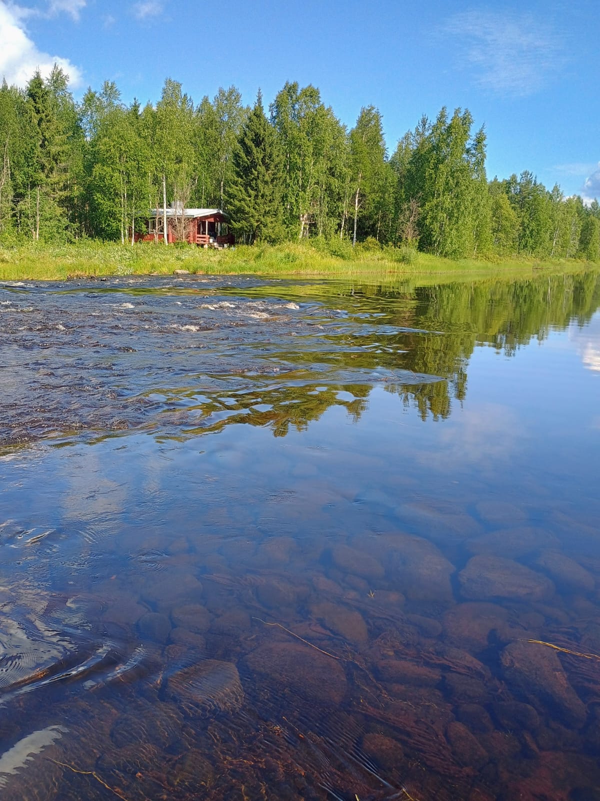 Erämökki Suomussalmi kuohuvan kosken rannalla